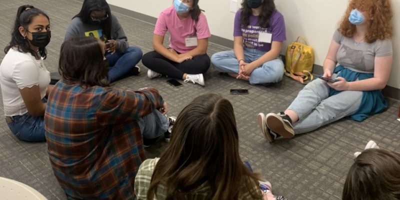 Group of teenage girls sitting in a circle talking