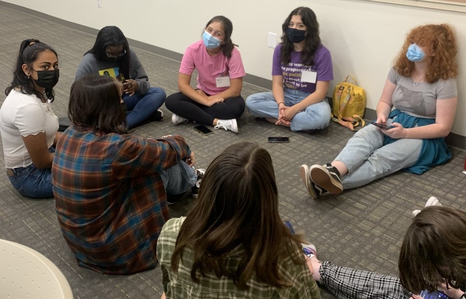 Group of teenage girls sitting in a circle talking